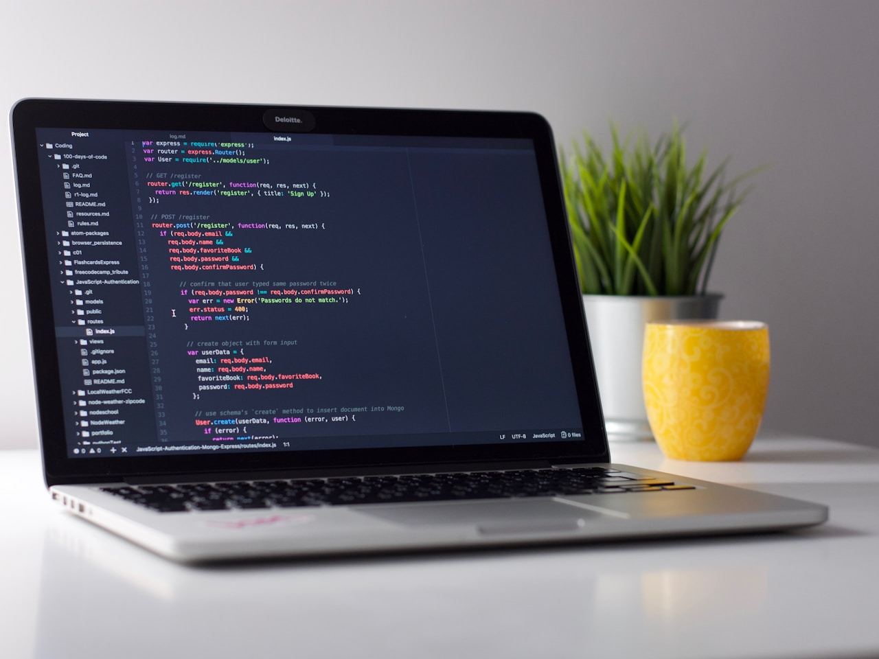 Close-up of a developer's hands typing code on a laptop with a code editor on screen